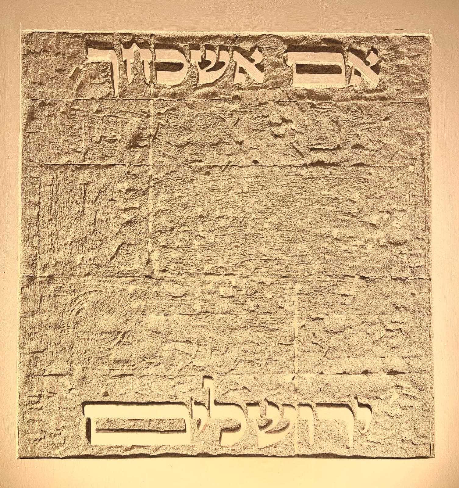 אריח סיתות בגוון אבן חולית: הכיתוב 'אם אשכחך' מסותת בקו דק בראש האריח ו'ירושלים' בקו עבה בתחתיתו; באמצע משטח מחוספס במרקם של אבן חצובה הרומז לבית המקדש בתבליט.